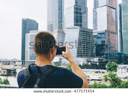 Young man tourist taking a shot in moscow on phone
