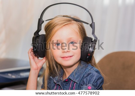 beautiful cheerful girl with long hair in big headphones listening to music
