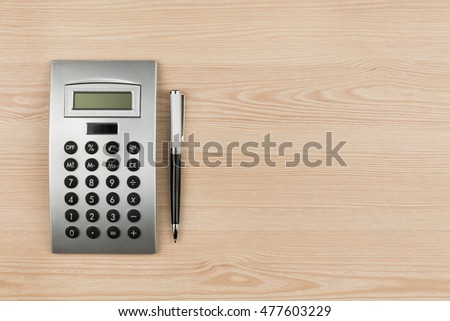 Close-up of luxury black pen and calculator on wooden desk, with space for your text