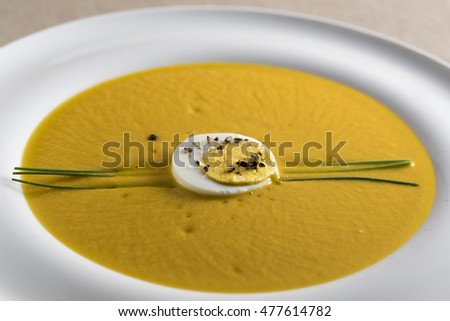 cream of pumpkin soup with boiled egg and chives pepper