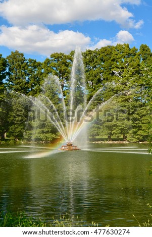 Rainbow Beam of Light in Fountain in Park Pond