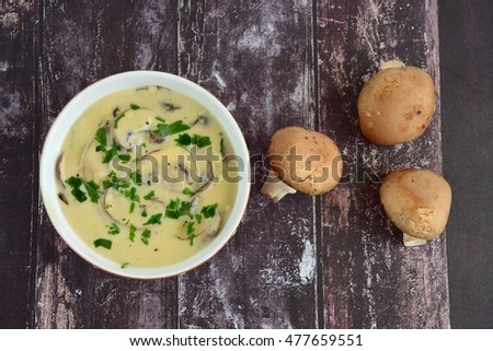 Cream of mushroom soup in a bowl on wooden background