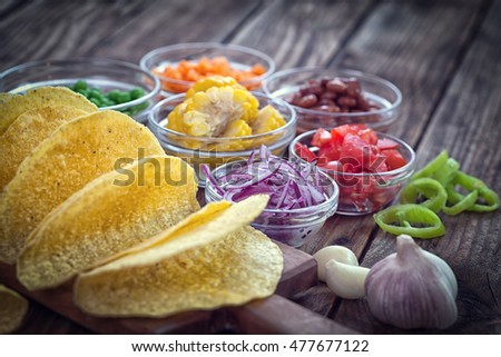 Mexican corn tortilla tacos with vegetables on wooden background
