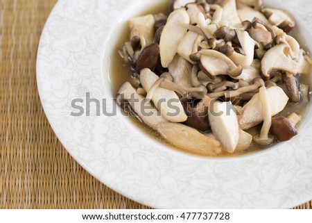 Stir fried mushroom in white dish on brown napery / Selective focus