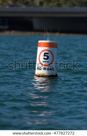 5 MPH No Wake Buoy floating in the harbor with orange notification tape and black lettering