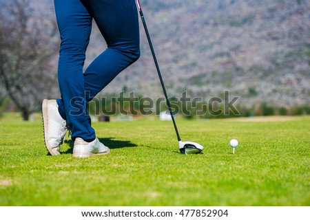 view of a golfer teeing off from a golf tee on a bright sunny day on a golf course in south africa