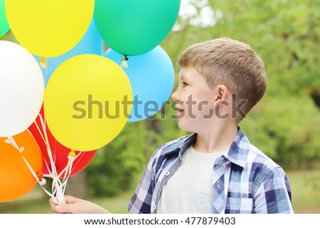 Llittle boy with balloons in the park