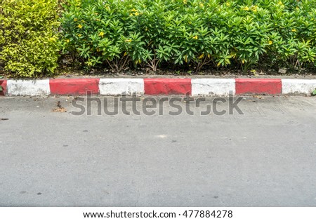 Concrete road with red and white curb