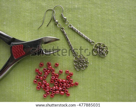 Red beads and tools for making earrings, handmade jewelry, macro mode