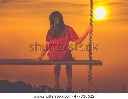 Single girl alone swinging on the mountain and looking the other seat missing a boyfriend
