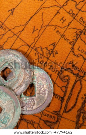 Ancient Chinese coins over antique map