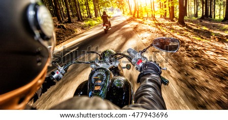 Motorcycle drivers riding on motorway in beautiful sunset light. Shot from pillion driver view Royalty-Free Stock Photo #477943696