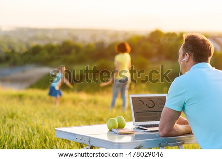 Handsome man enjoying laptop outdoors