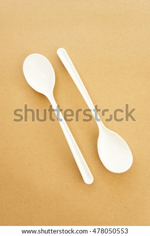Twin spoons on brown background ,White spoon, The device is one of the cooking container. in eating