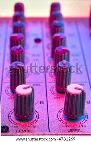 two lines of a mixer console close up with disco colors