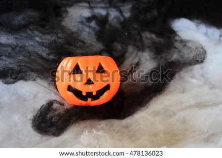 Plastic pumpkin buckets on black and white smoke background