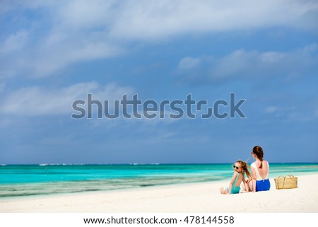Mother and daughter enjoying tropical beach vacation