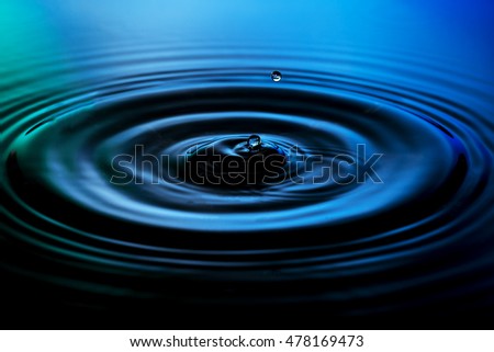 Blue water drops falling down on nice blue green background.
