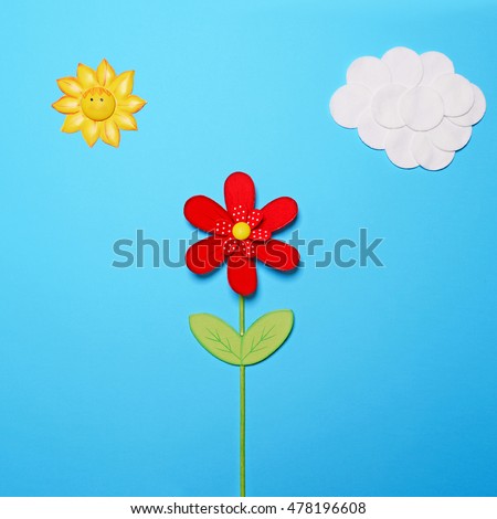 Fairy tail scene made of various objects on blue paper - Childrens story background - Cotton clouds and sun with red wooden flower against blue paper - Flat lay