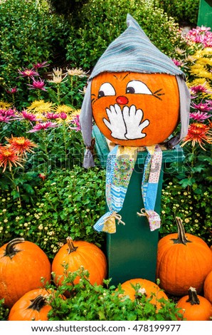 Halloween pumpkin covers her mouth with her hands