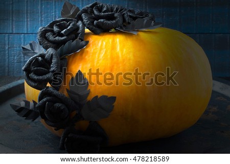 / Idea homemade decorating for Halloween. Black Roses of crepe paper on the pumpkin.  The original design in the style of Halloween. Tinted photo