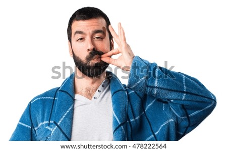 Man in dressing gown making silence gesture