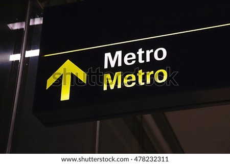 Metro sign underground glowing on a dark corridor