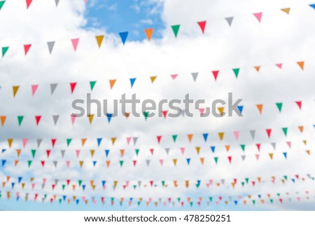 Blur image of  triangle flags with blue sky and white cloud background, intention blur , for background usage
