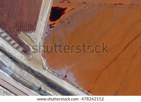 Aerial View of Bright Colored Tailing Ponds with Roads and Infrastructure Shot with Drone on a Sunny Day
