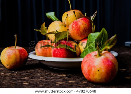 Fresh harvest of apples. Nature theme with container plate bowl on wooden background. Nature fruit concept.
