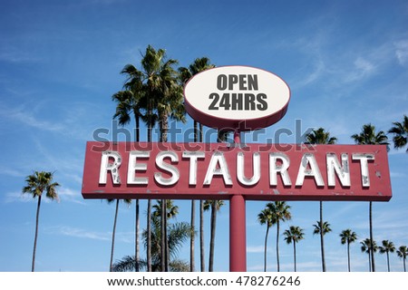 aged and worn vintage photo of old neon restaurant sign with palm trees                             