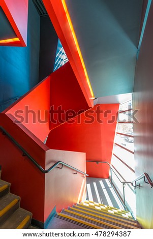 Staircase painted in red. Abstract fragment of urban architecture of modern luxury building, center, hotel, shopping mall, business centre.   Interior design.