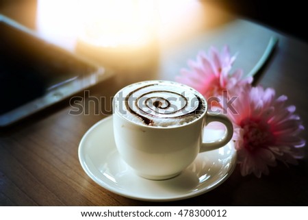 Coffee beside with Flower and tablet on the wood table
