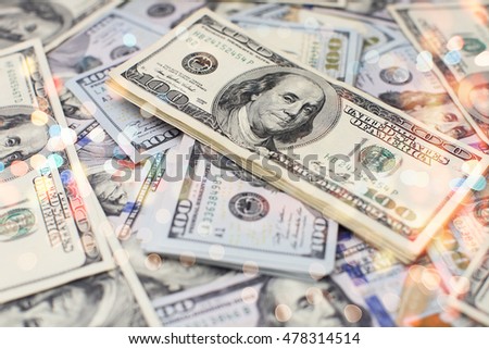 A stack of money. Heap of one hundred dollar bills on money background. Fake money. Shallow depth of field. Selective focus.