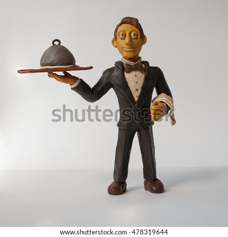
Photo Plasticine figurine waiter with a tray in his hand . The original character for your design Royalty-Free Stock Photo #478319644