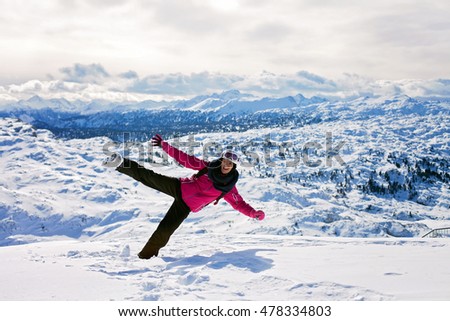 Young attractive woman, skiing in Austrian ski resort on a sunny day, wintertime