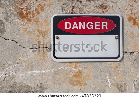Danger sign on cool rough old stone weathered wall