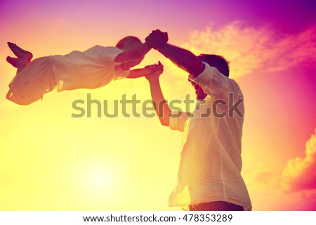 Father with his little son playing together, dad and child having fun outdoors. Joyful Family. Free, freedom concept. Summer Holidays, vacation
