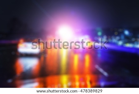 lighting of police car at night during accident on the road when raining.  -blurred picture.