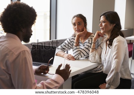Mother And Daughter Meeting With Male Teacher Royalty-Free Stock Photo #478396048