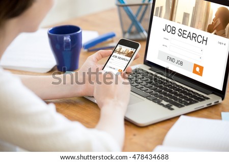 Young business woman working in office interior, searching for job online. Female looking for job using web service on smartphone. Close-up of hands holding phone. HR, recruitment, career concept Royalty-Free Stock Photo #478434688