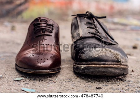 Conceptual shooting of shoes. Old shabby shoes in comparison with new and expensive ones. Royalty-Free Stock Photo #478487740