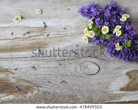Natural background with bouquet of lavender and daisy flowers on a wooden plank. Top view of a bunch of purple lavandula flowers on a wooden background. Photo from above.