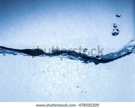 Water splash on blue background. Close up of splash of water forming unique wave shape,