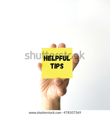 Hand holding yellow sticky note written HELPFUL TIPS word