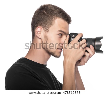 Handsome young man holding a DSLR camera. On white.