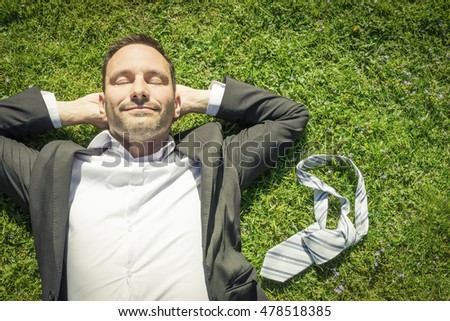 happy man lying in the grass relaxing and smiling Royalty-Free Stock Photo #478518385