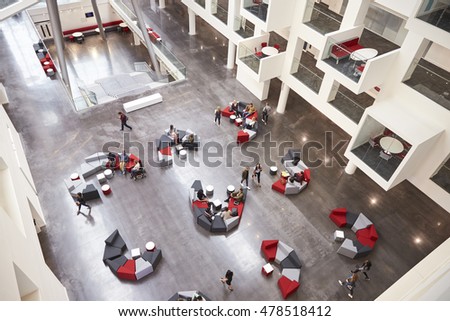 Students in the atrium of modern university building, aerial