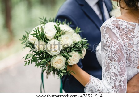 Happy bride and groom on their wedding hugging Royalty-Free Stock Photo #478521514