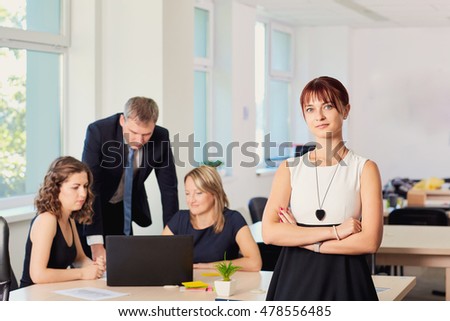 Portrait of business woman in the office in a chair on the background of working business partners.